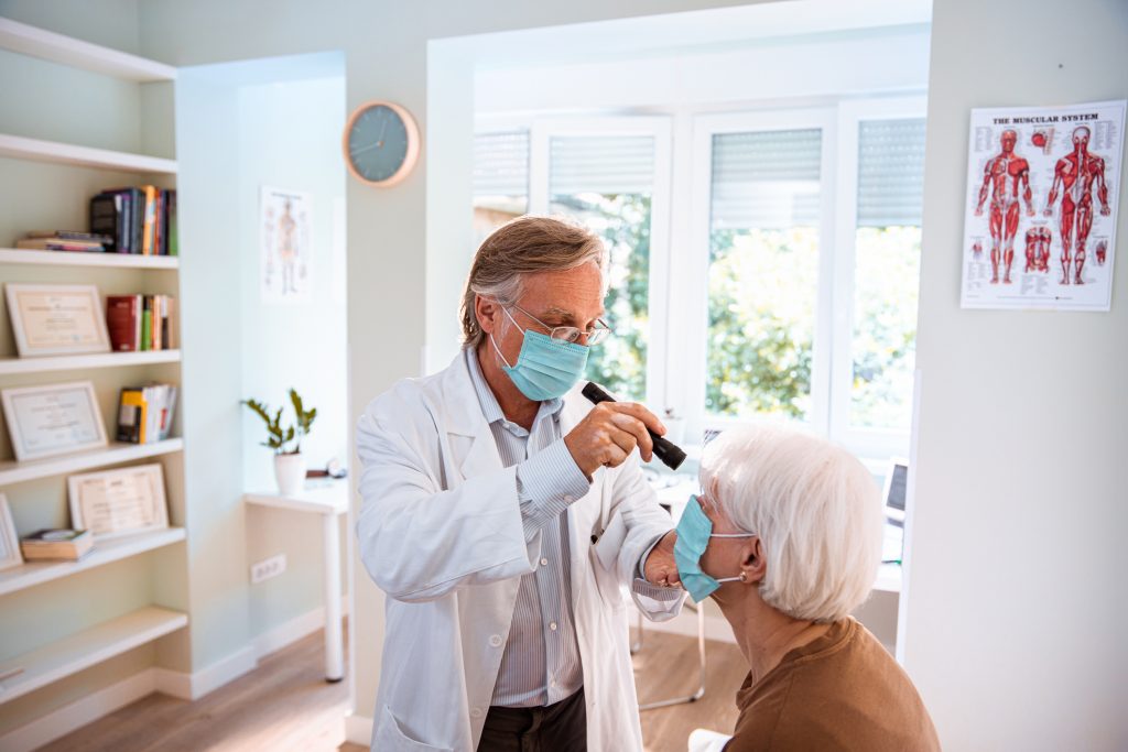 senior woman gets eye exam with a doctor