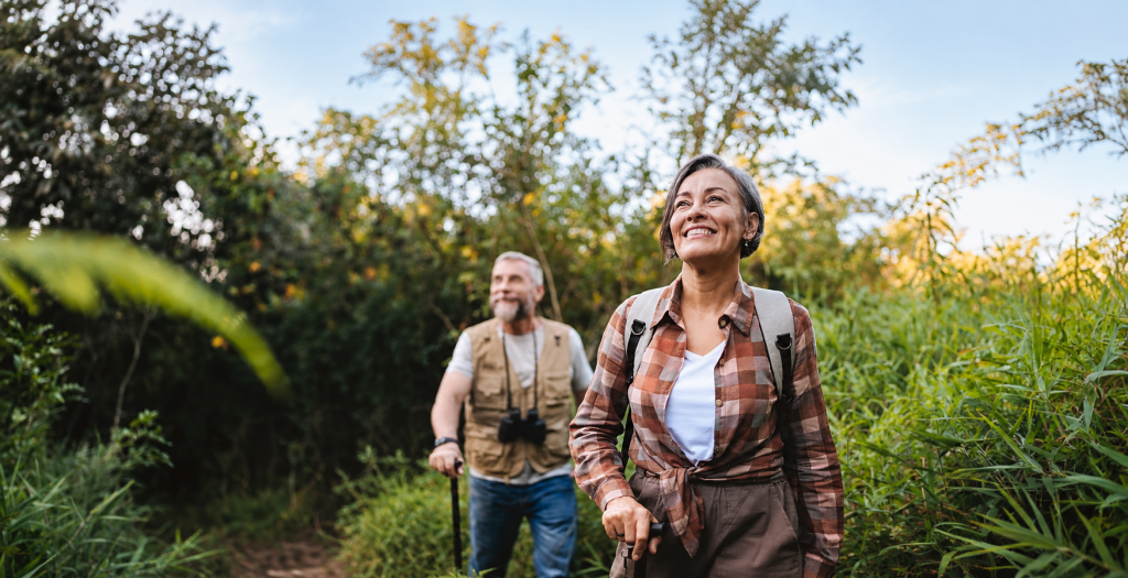 Senior couple walking on forest mountain trail